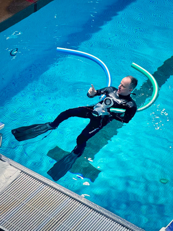 Photographer Finn Ohara in a pool conducting a photoshoot using Outex camera and flash waterproof case.