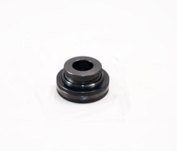 The Outex Accessories Miscellaneous Copy is a black metal circular camera adaptor with ridged edges, ideal for tripods or cable adaptors.