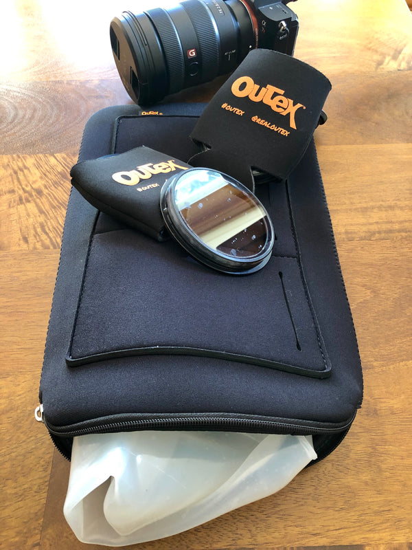 Outex Maintenance and Care kit with accessories, lens, and filter displayed on a padded black case.