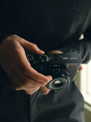 Person holding a Fujifilm X100 camera — compatible with Outex waterproof underwater housing system
