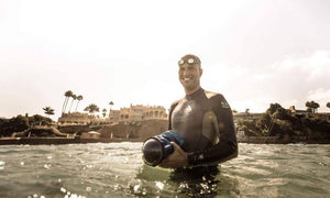 Outex co-founder JR deSouza holding camera on surf break inside Outex waterproof camera housing