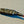 Coiled black cable with a red end on a gray surface