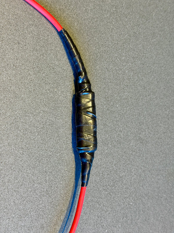 Fused electrical cable with red and blue wires on a gray background