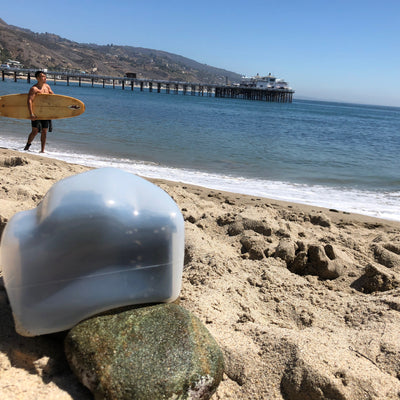 Camera with an Outex case on a beach taking a photo of a surfer