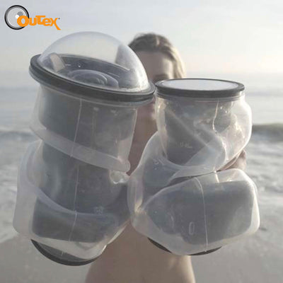 Woman on the beach is holding 2 cameras that have an Outex case